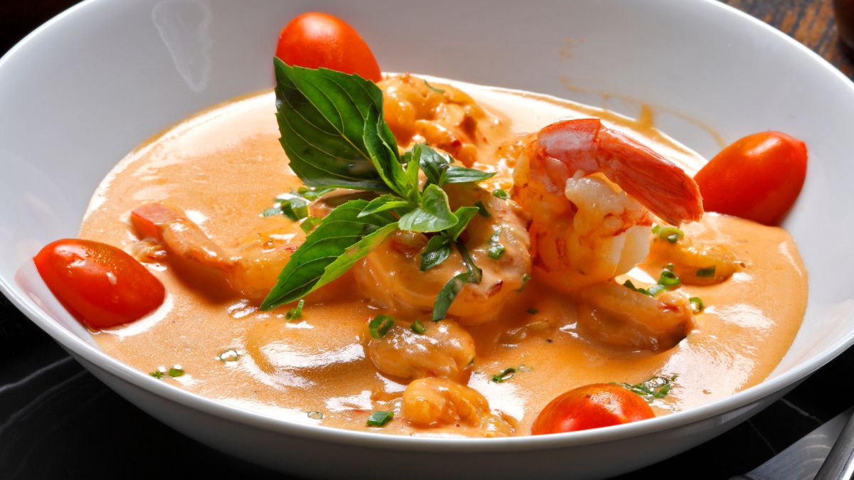 Shrimp in Panera SIgnature Sauce with tomatoes and basil, served on a white plate
