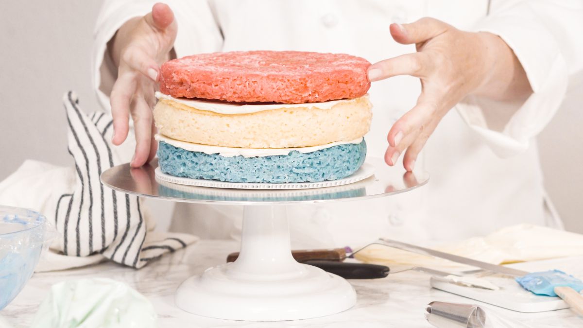 a pastry chef stacking layers for a layer cake