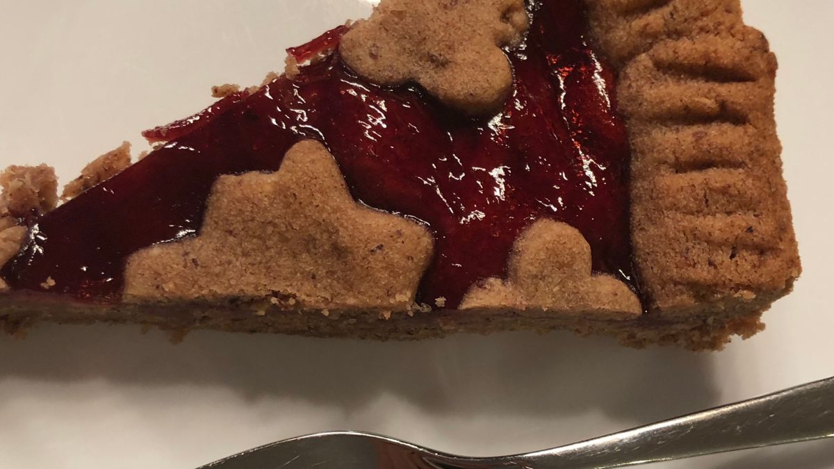 a piece of linzer torte on a white plate with a fork