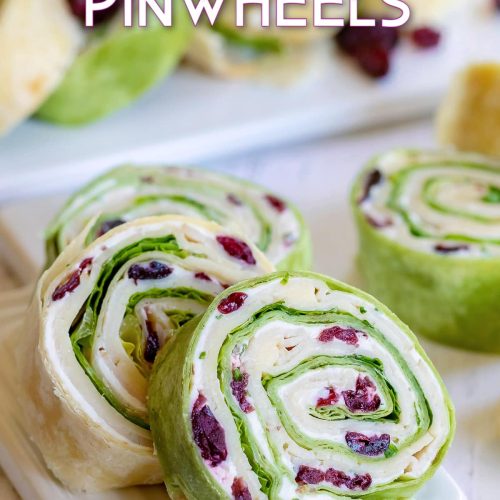 turkey pinwheels recipe with dried cranberries on small white cutting board