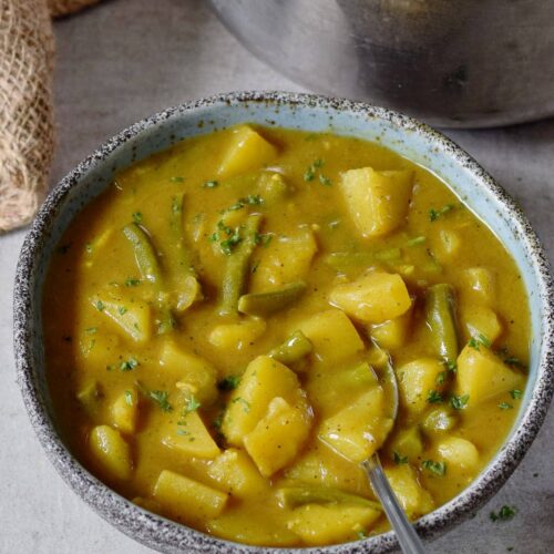 vegan potato curry with green beans in a bowl